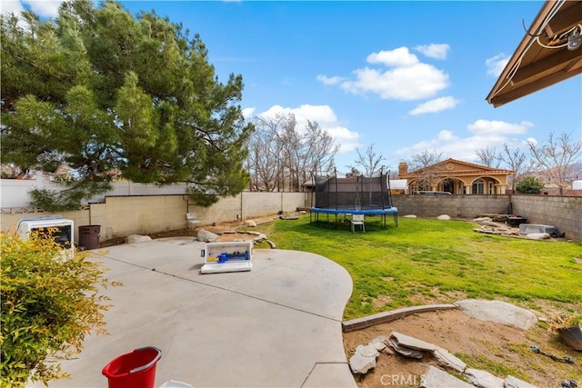 view of yard with a patio area, a trampoline, and a fenced backyard