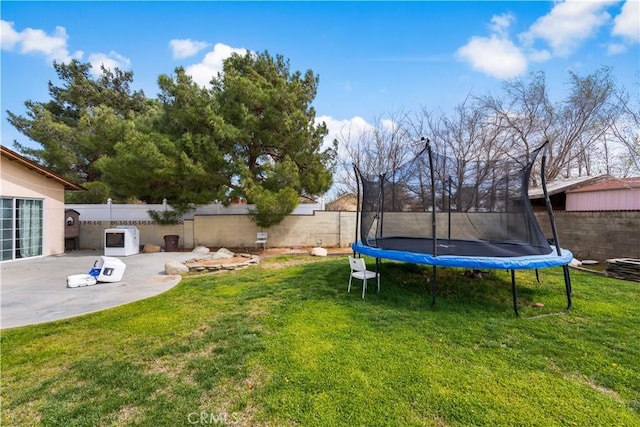 view of yard featuring a patio area, a fenced backyard, and a trampoline