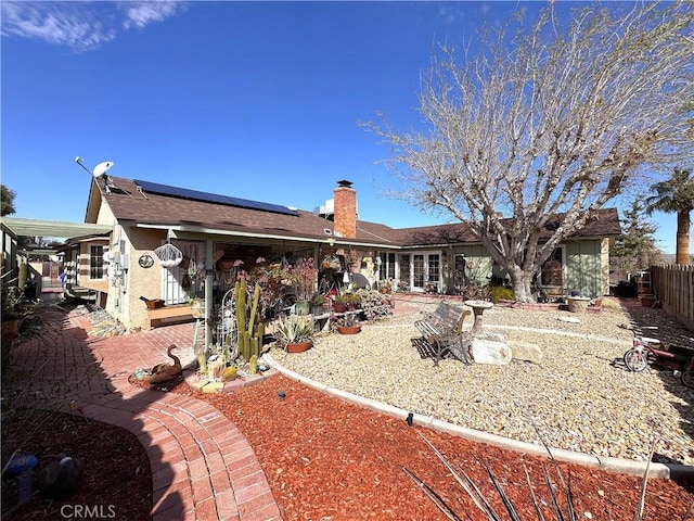 433 Oakmont Dr, Barstow, CA 92311 - rear view of house featuring solar panels, fence, stucco siding, a chimney, and a patio