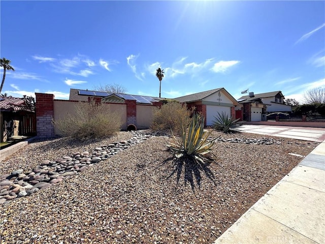 433 Oakmont Dr, Barstow, CA 92311 - view of front of home with solar panels, fence, concrete driveway, stucco siding, and an attached garage