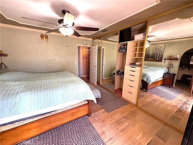 433 Oakmont Dr, Barstow, CA 92311 - bedroom with arched walkways, wood finished floors, a ceiling fan, and ornamental molding