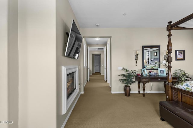 hallway featuring baseboards and carpet