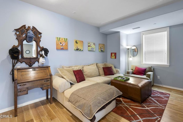 living room with visible vents, baseboards, and wood finished floors