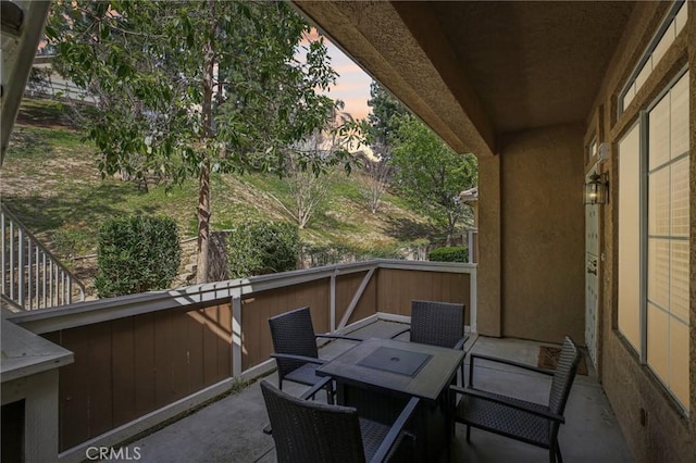 balcony at dusk with outdoor dining space