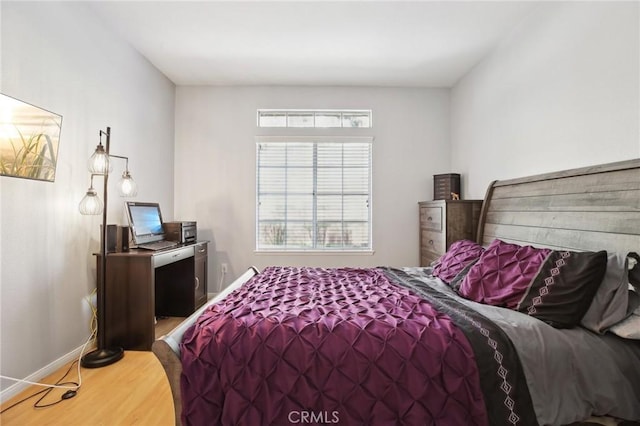 bedroom featuring baseboards and wood finished floors