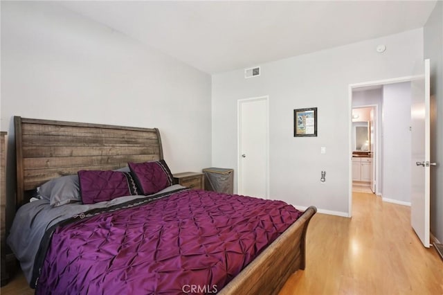 bedroom with baseboards, visible vents, and light wood-style floors