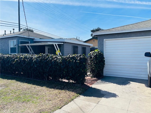 155 E Century Blvd, Los Angeles, CA 90003 - view of side of home with a garage, a yard, concrete driveway, and stucco siding