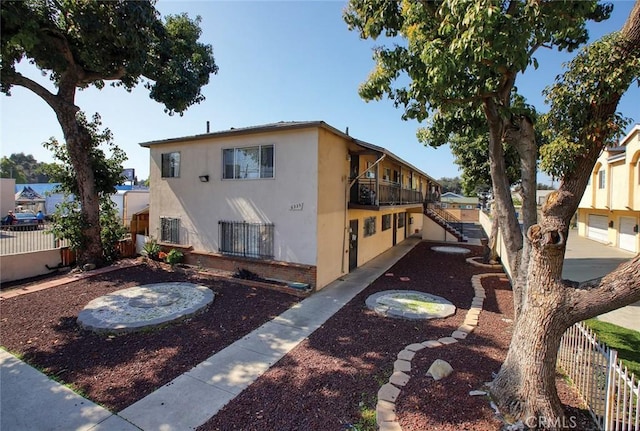 6335 Loma Vista Ave, Bell, CA 90201 - view of side of home with stucco siding, a balcony, and stairway