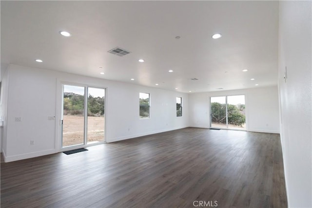 unfurnished living room with visible vents, recessed lighting, dark wood-type flooring, and baseboards