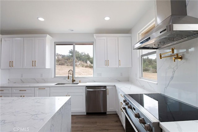 kitchen with a healthy amount of sunlight, stainless steel appliances, wall chimney exhaust hood, and a sink