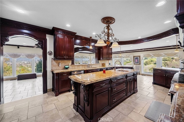 kitchen featuring ornamental molding, a sink, tasteful backsplash, and plenty of natural light