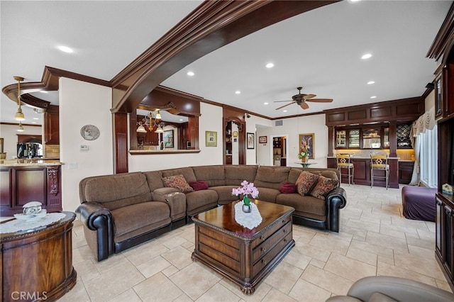 living room featuring a ceiling fan, ornamental molding, recessed lighting, and arched walkways
