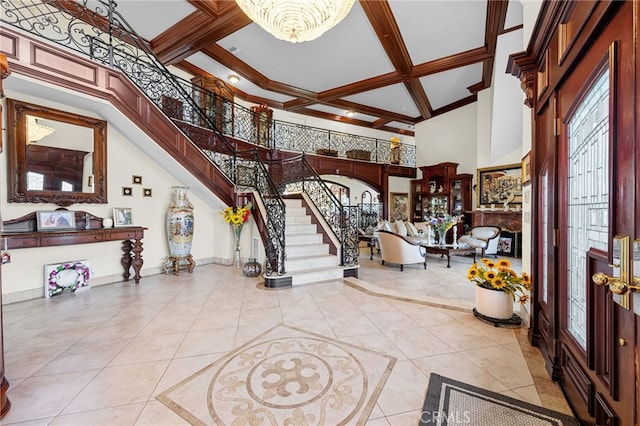foyer entrance featuring stairs, beamed ceiling, a notable chandelier, a high ceiling, and light tile patterned flooring