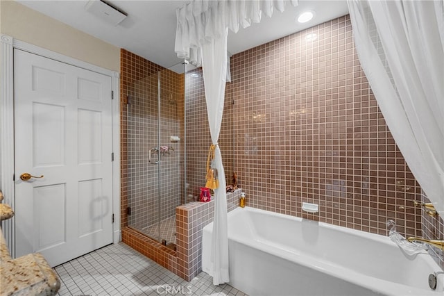 bathroom featuring tile patterned flooring, a shower stall, and a washtub