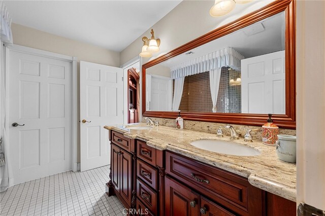 bathroom with tile patterned flooring, double vanity, and a sink
