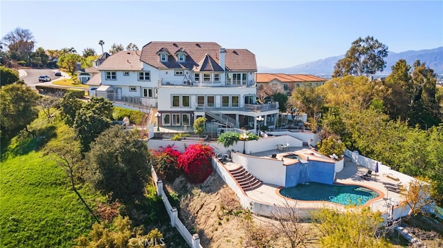 rear view of house featuring stairway, fence, a fenced in pool, a patio area, and a balcony
