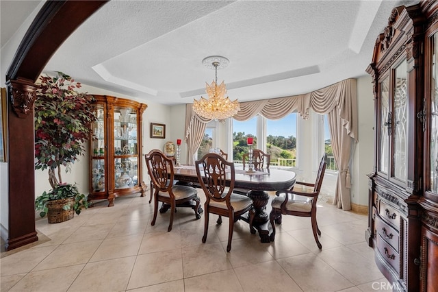 dining area featuring a chandelier, light tile patterned floors, a tray ceiling, baseboards, and a textured ceiling