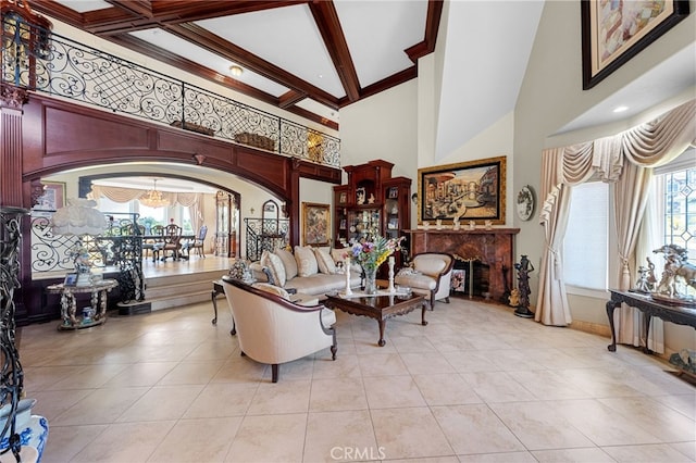 living area with a chandelier, arched walkways, a towering ceiling, and plenty of natural light