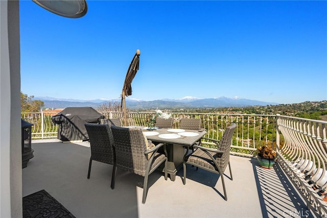 balcony featuring a mountain view and outdoor dining space