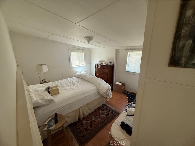 bedroom with vaulted ceiling and wood finished floors