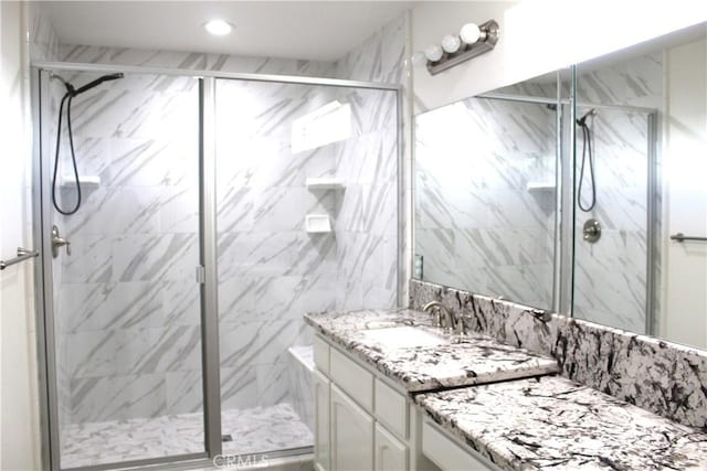 full bath with vanity, recessed lighting, and a marble finish shower