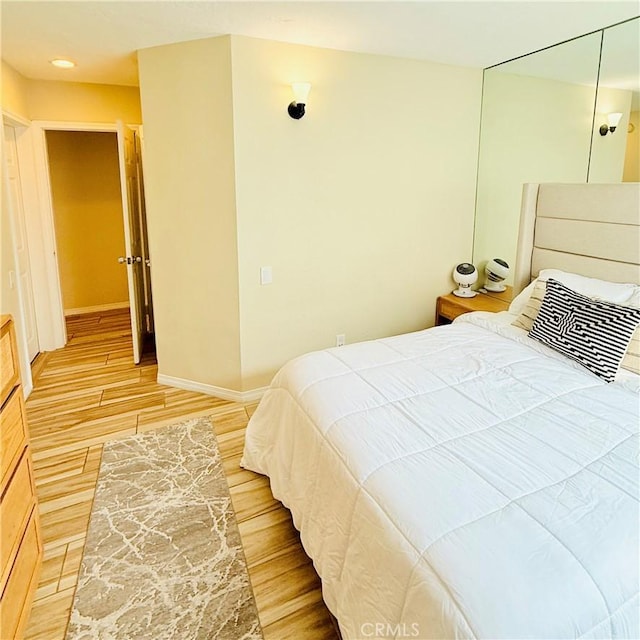 bedroom featuring light wood-style floors and baseboards
