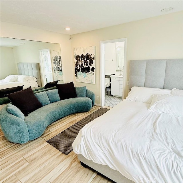 bedroom featuring connected bathroom and wood finished floors