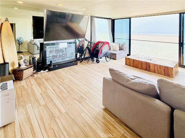 living area featuring light wood-type flooring and floor to ceiling windows