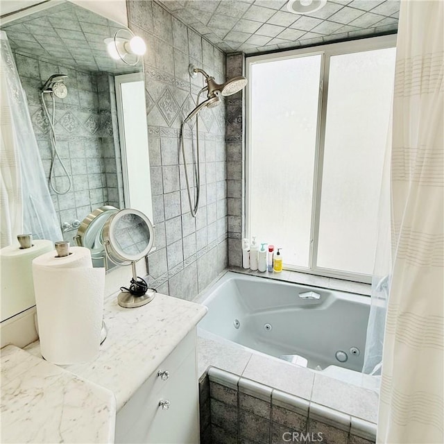 full bath featuring vanity, tile walls, and a combined bath / shower with jetted tub
