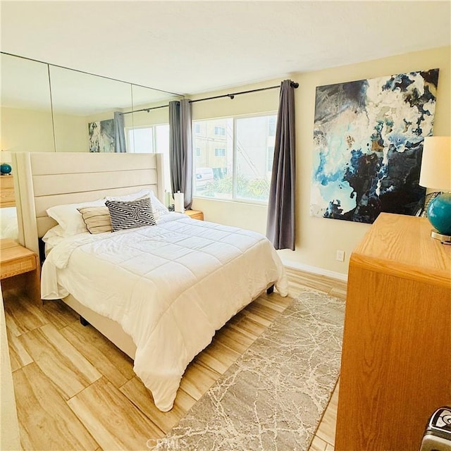 bedroom featuring baseboards and light wood-style floors