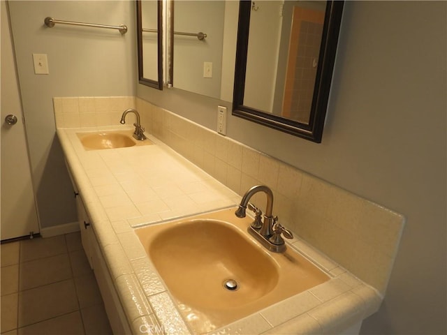 bathroom featuring a sink, double vanity, and tile patterned floors