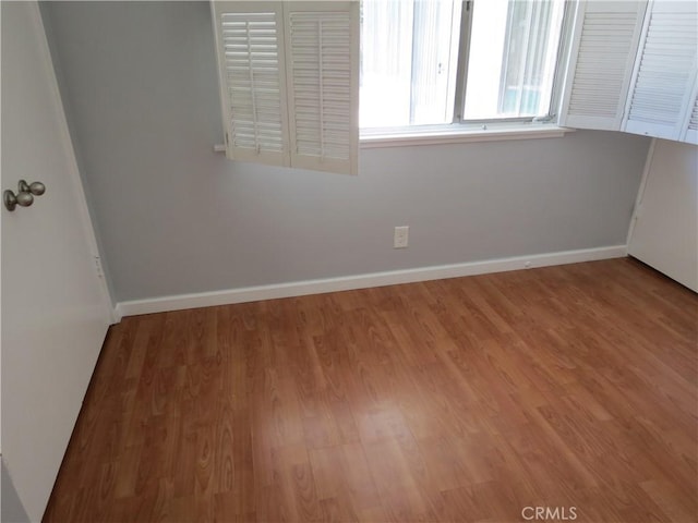 spare room with wood finished floors and baseboards
