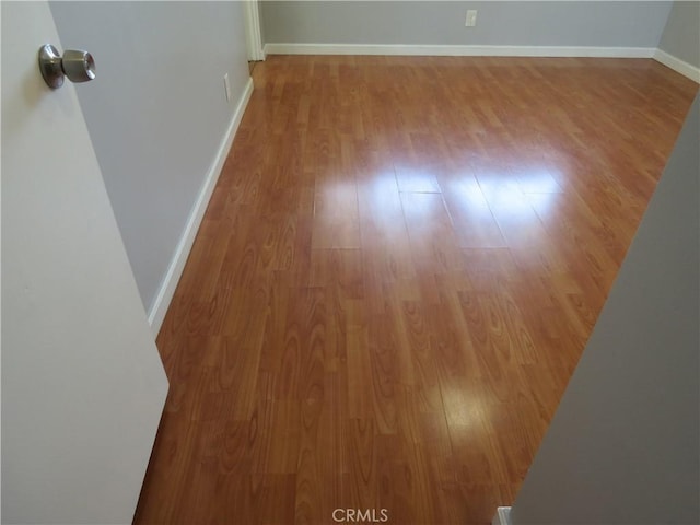 spare room with wood finished floors and baseboards