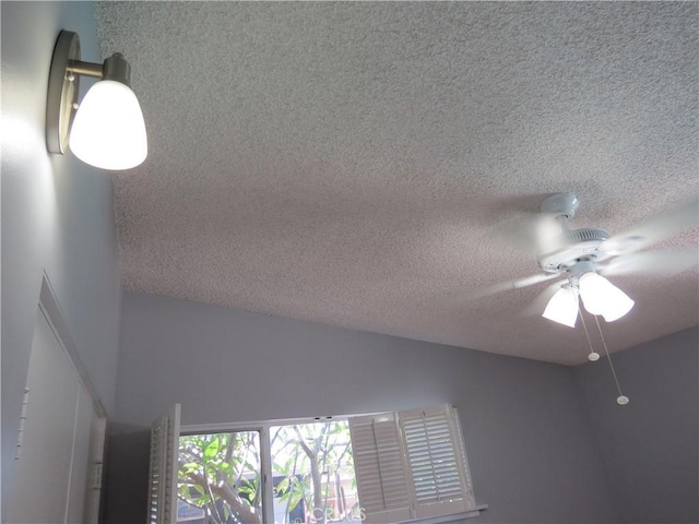 interior details with ceiling fan and a textured ceiling