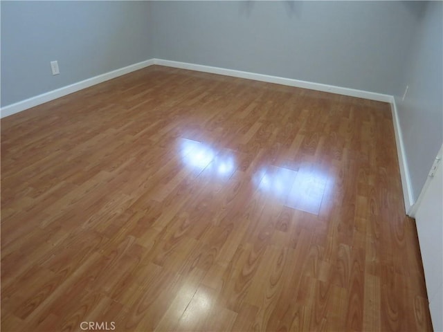 unfurnished room featuring baseboards and wood finished floors
