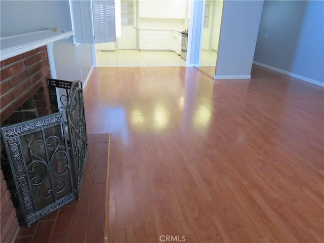 unfurnished living room with baseboards and wood finished floors