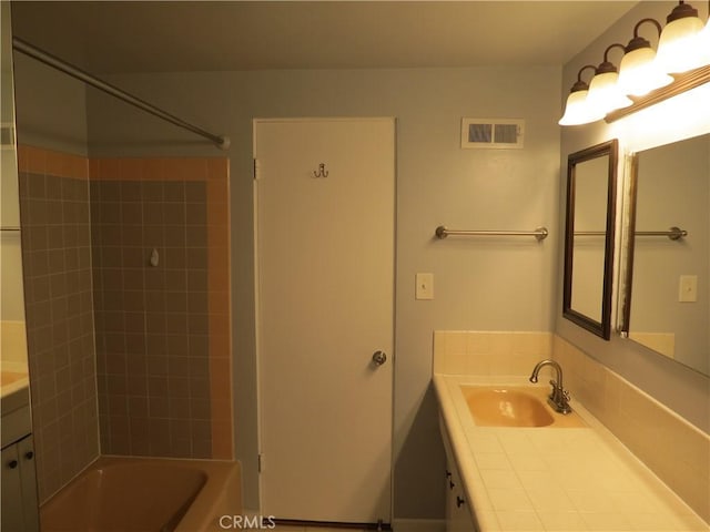 bathroom with visible vents, bathing tub / shower combination, and vanity