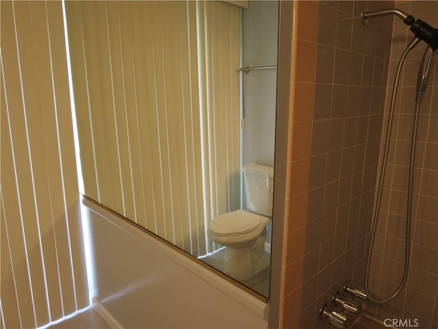 full bathroom with tiled shower and toilet