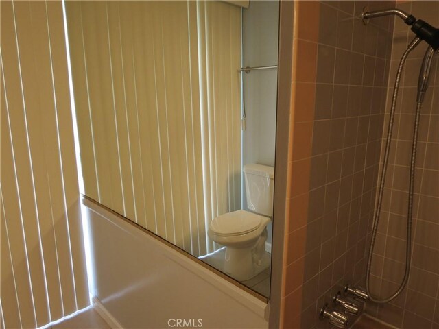 bathroom featuring toilet and a tile shower
