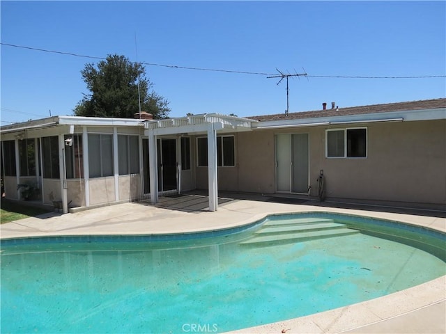 pool with a patio and a sunroom