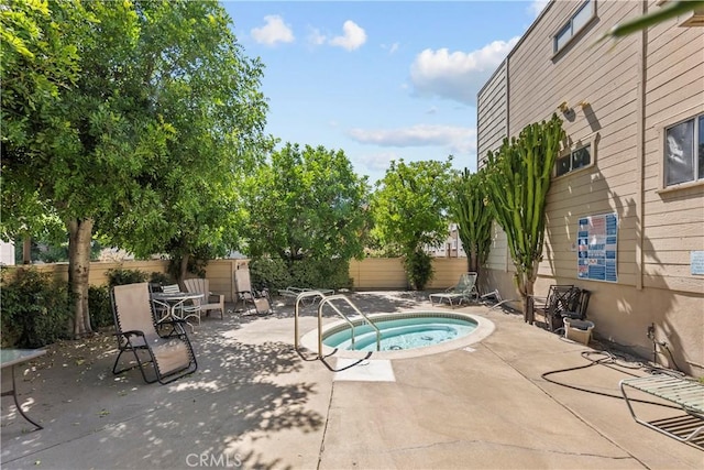 view of pool featuring fence, a community hot tub, and a patio