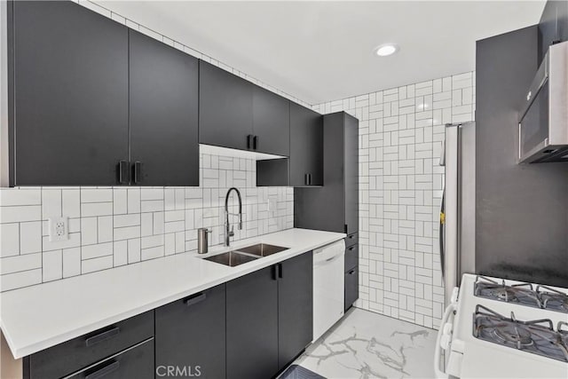 kitchen with light countertops, white appliances, marble finish floor, a sink, and dark cabinets