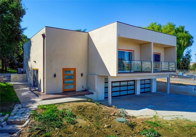 21655 Temescal Canyon Rd, Corona, CA 92883 - view of front of home with stucco siding, a balcony, concrete driveway, and an attached garage