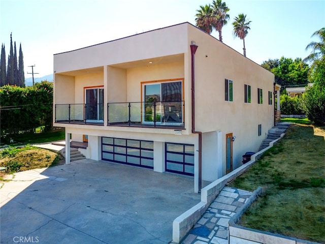 21655 Temescal Canyon Rd, Corona, CA 92883 - contemporary home with stucco siding, a balcony, concrete driveway, and an attached garage