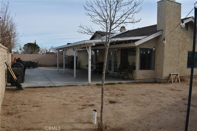 36913 Tobira Dr, Palmdale, CA 93550 - back of house with a patio area, french doors, a fenced backyard, a chimney, and stucco siding