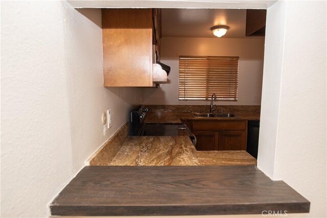 719 N Eucalyptus Ave Unit 19A, Inglewood, CA 90302 - kitchen featuring a sink, stove, a textured wall, and dark countertops