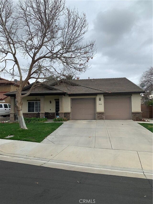 view of front facade featuring a front yard, stucco siding, concrete driveway, a garage, and stone siding
