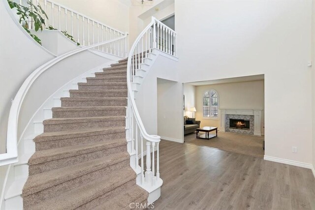 1618 Southport Dr, Riverside, CA 92506 - stairs with wood finished floors, a towering ceiling, baseboards, and a fireplace