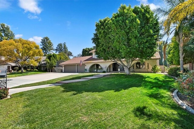 1618 Southport Dr, Riverside, CA 92506 - view of front of home with an attached garage, driveway, a front lawn, and stucco siding