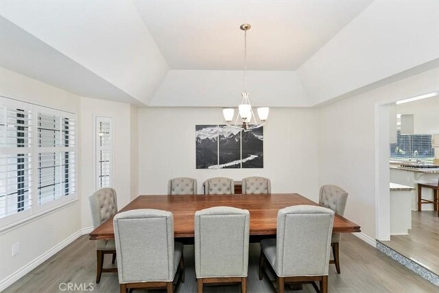 1618 Southport Dr, Riverside, CA 92506 - dining area featuring a chandelier, a tray ceiling, light wood finished floors, and baseboards